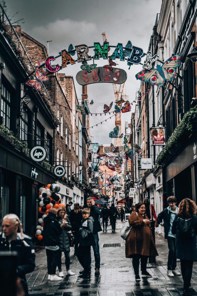 Explore the bustling atmosphere of Carnaby Street in London with colorful decorations and lively crowds.