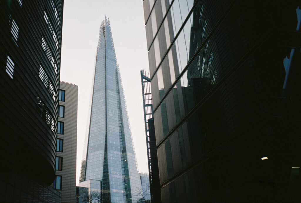Low angle shot of The Shard skyscraper framed by urban architecture.