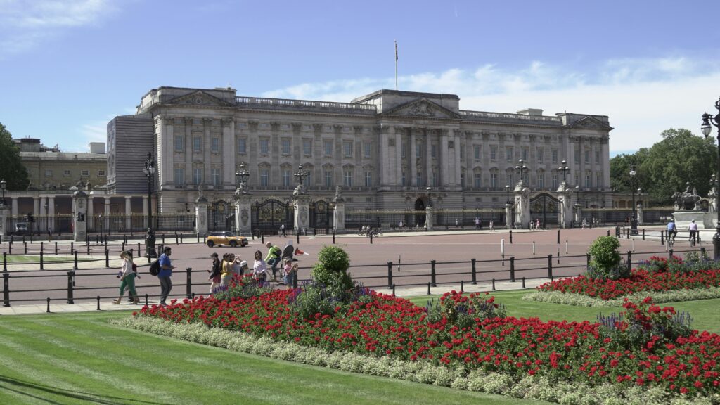 View of Buckingham Palace with lush gardens on a sunny day in London.