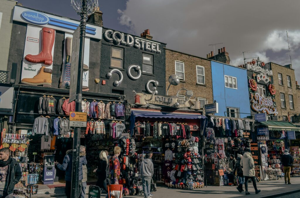 A vibrant street view of Camden Market in London showcasing quirky fashion shops and bustling activity.