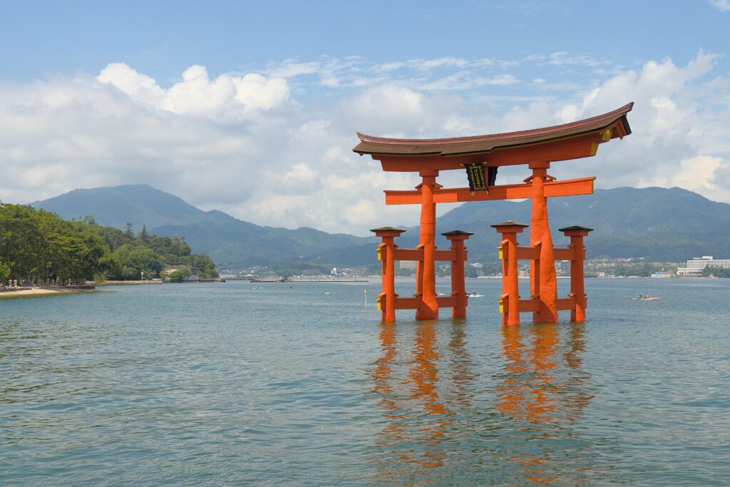 Explore the stunning red Torii gate at Miyajima, set against serene waters and picturesque landscapes.