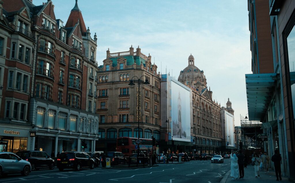 Evening view of a busy street in London with iconic architecture and city life.