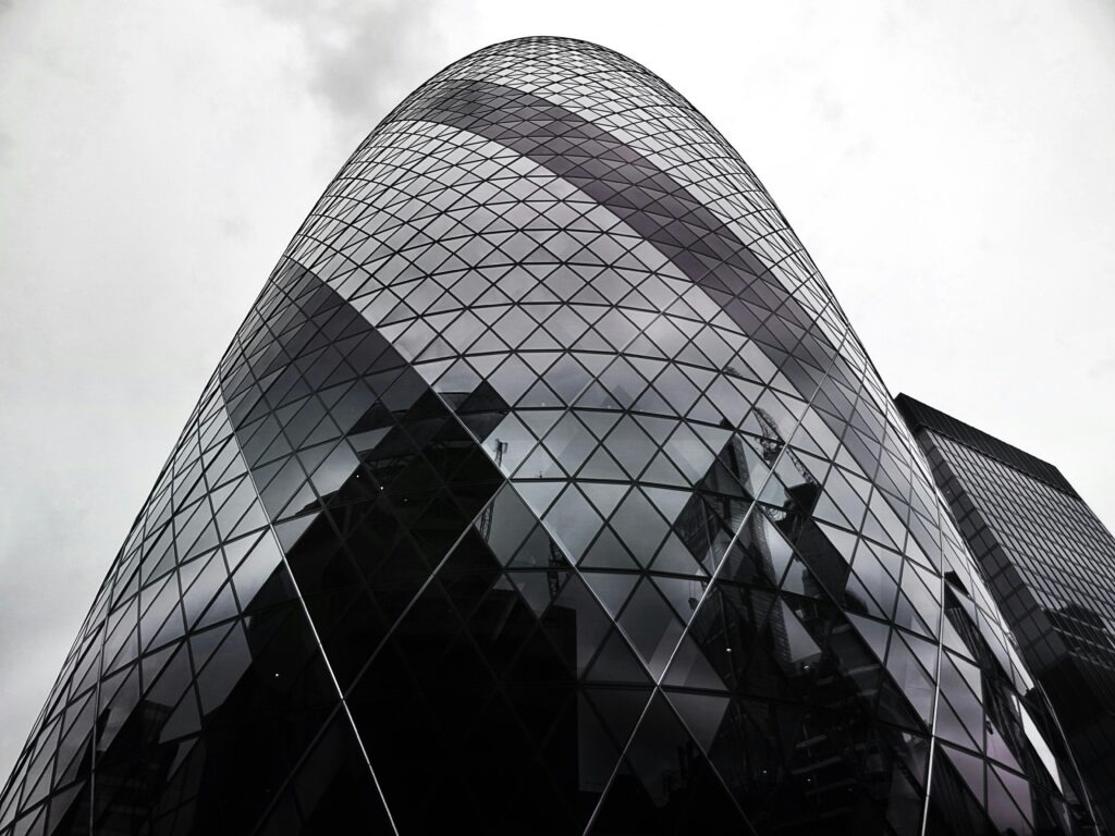 Modern architectural marvel, the Gherkin, stands tall against a cloudy London sky.