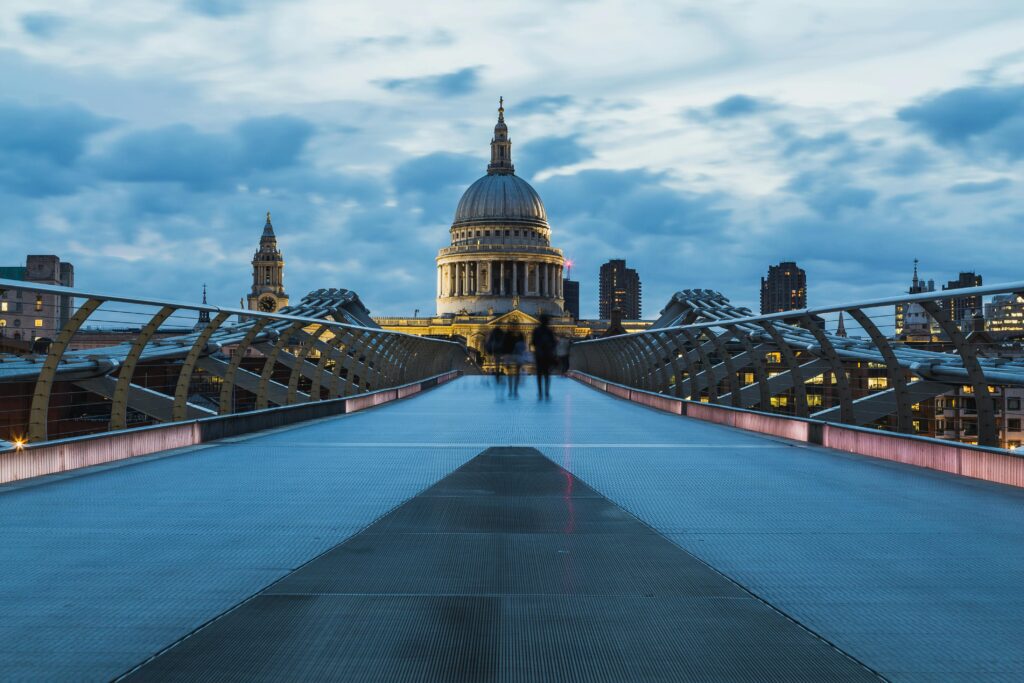 A striking shot of St Paul's Cathedral in London taken from Millennium Bridge at dusk, highlighting modern architecture.