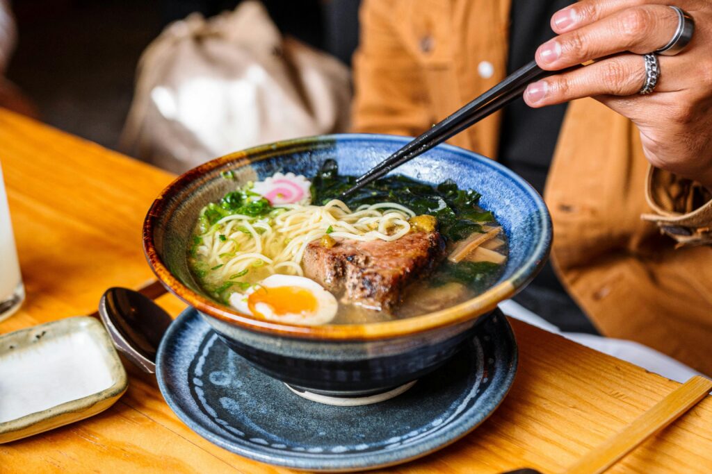 A vibrant bowl of ramen with chopsticks, showcasing a perfect mix of ingredients.